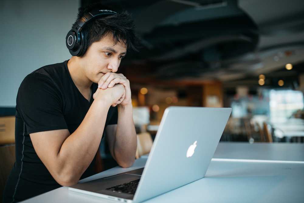 man wearing headphones while sitting on chair in front of MacBook nick ang blog