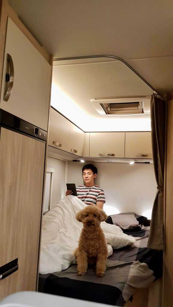nick reading his kindle with Brownie on a campervan