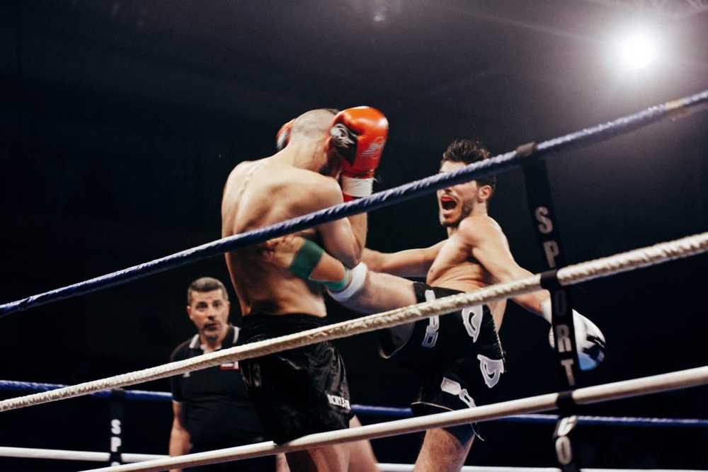 muay thai guy kicking opponent in the ring