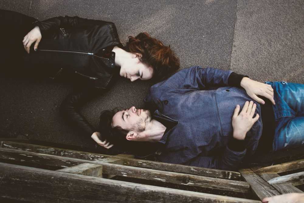 two people lying side by side looking into each other's eyes